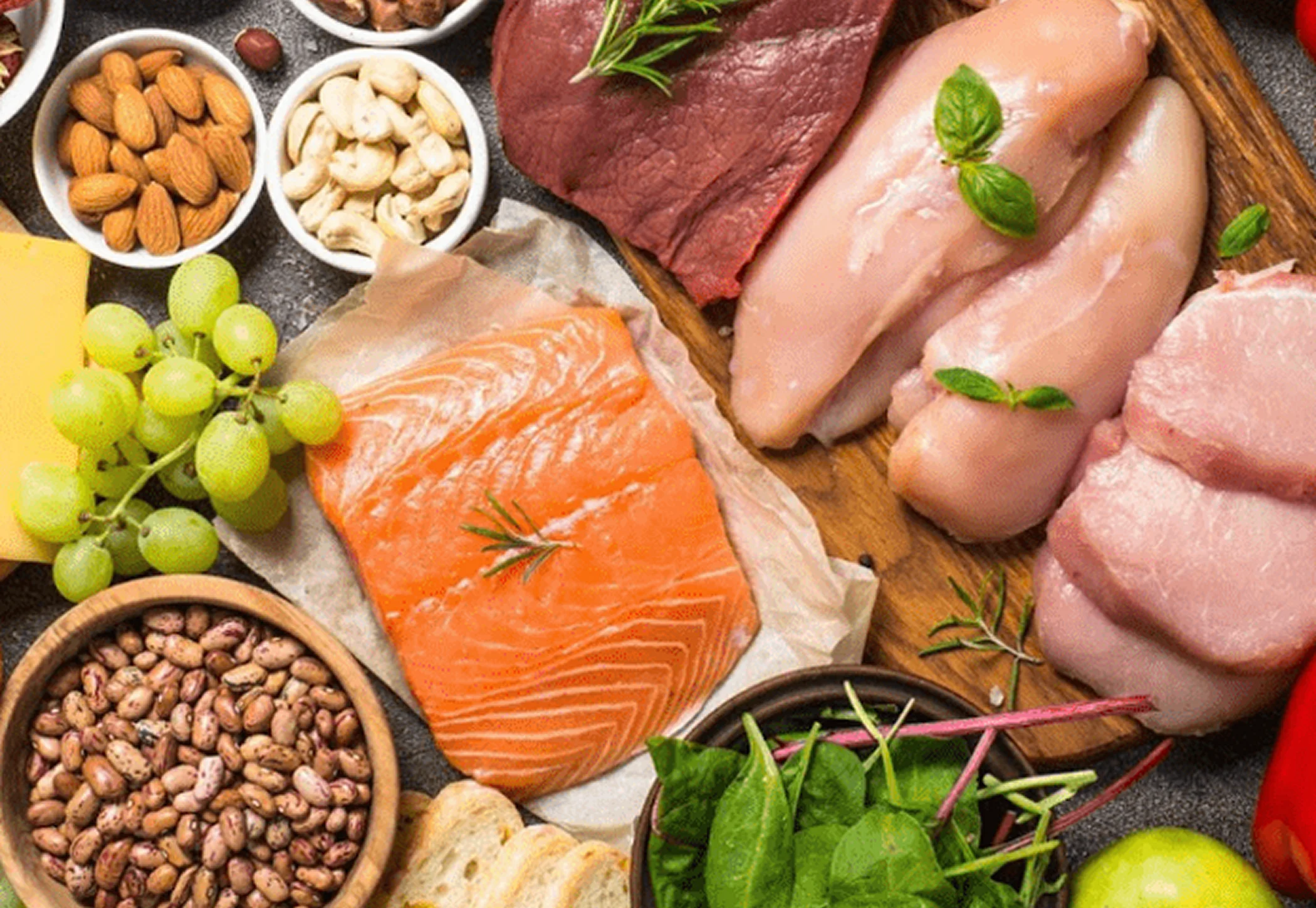 A healthy, balanced spread of food with meat, fish, fruit, veg, bread, cheese, nuts and more.